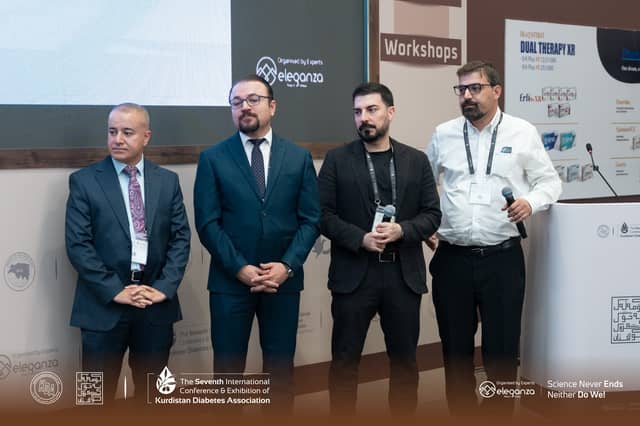 Dr. Karzan standing on stage with three fellow panellists