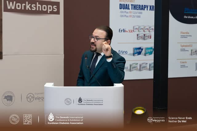 Dr. Karzan gesturing as he speaks at the lectern