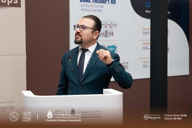 Dr. Karzan at the lectern, mid-sentence