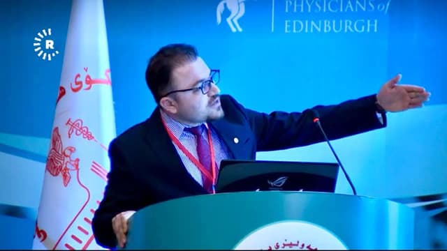 Dr. Karzan Mohammed Abdullah speaking at a lectern during a medical conference
